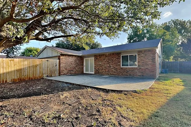 a backyard of a house with a large tree