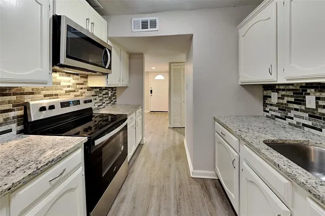 a kitchen with stainless steel appliances granite countertop a stove microwave and sink
