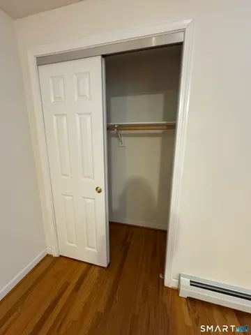 an empty room with wooden floor and closet