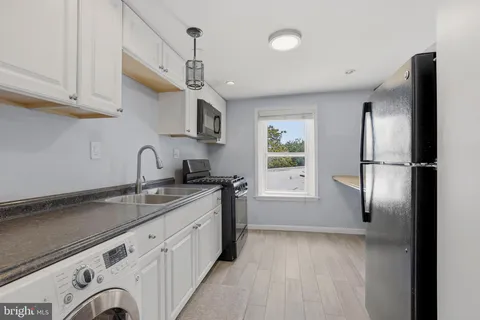 a kitchen with stainless steel appliances granite countertop a sink a refrigerator and a stove
