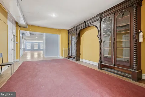 a view of an empty room with glass door and wooden floor