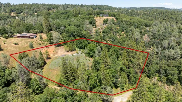 an aerial view of a house with a yard and lake view