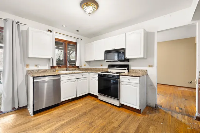 a kitchen with granite countertop a stove top oven and refrigerator