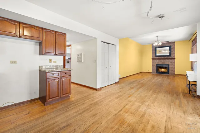 a view of an empty room with a fireplace and a window