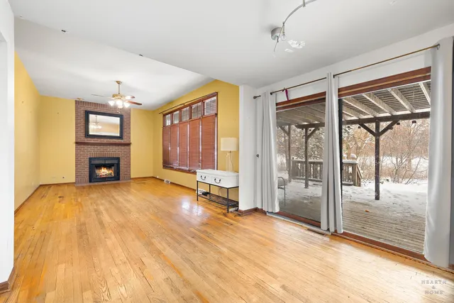 a view of an empty room with a window and a kitchen