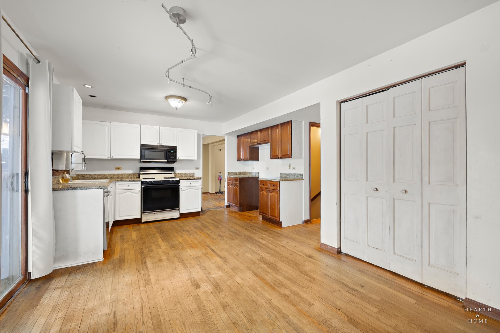 1207 Quail Run Avenue Bolingbrook, IL 60490 - Photo 34 of 48 a kitchen with granite countertop a refrigerator oven a sink dishwasher and white cabinets with wooden floor