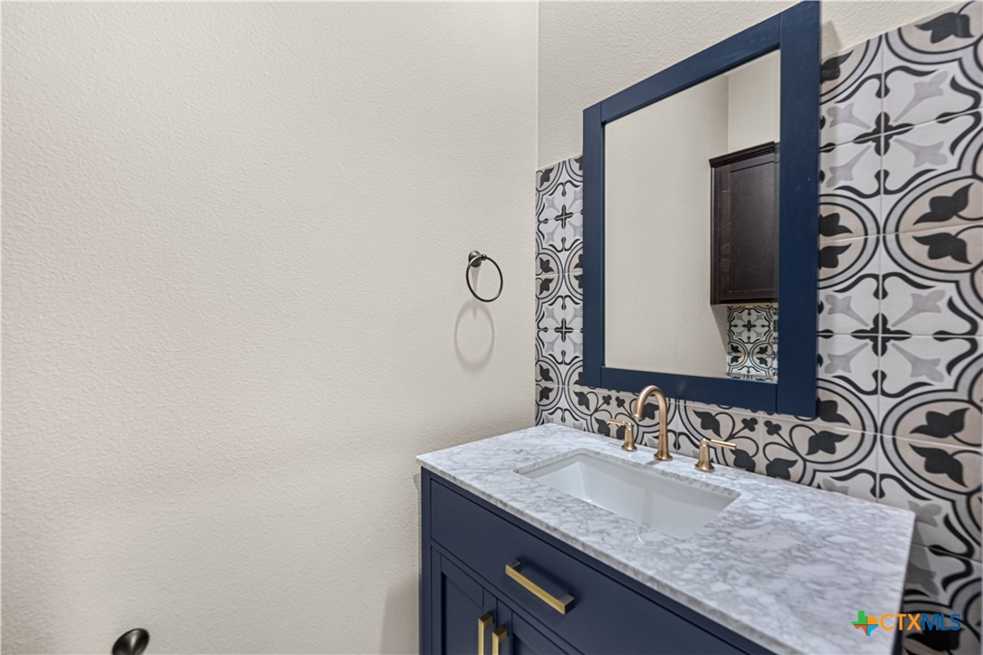 2136 Oak Draw Court Belton, TX 76513 - Photo 16 of 46 a bathroom with a granite countertop sink and a mirror