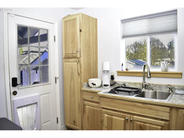 a kitchen with a refrigerator and a view of living room