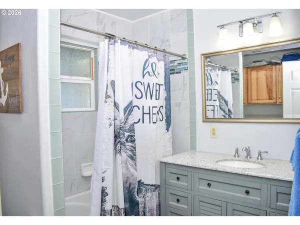 a bathroom with a granite countertop sink and a mirror