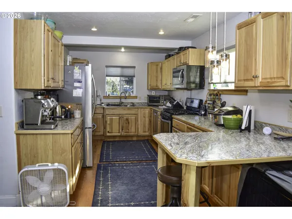 a kitchen with kitchen island granite countertop a sink cabinets and wooden floor