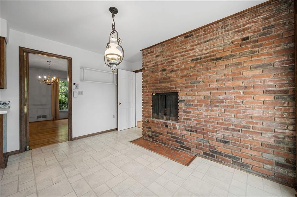 45 Stonedale Road Sewickley, PA 15143 - Photo 22 of 26 The kitchen combines functionality and charm with a central island, ample counter space, abundant cabinetry and a brick fireplace adding rustic appeal.