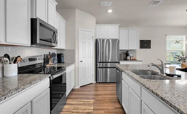 a kitchen with stainless steel appliances granite countertop a sink stove and refrigerator