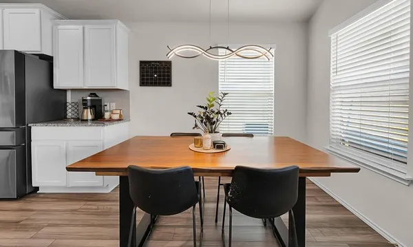 a dining room with table chairs and wooden floor