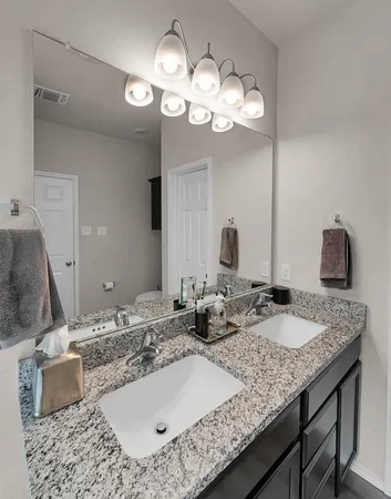 a bathroom with a granite countertop sink and a mirror