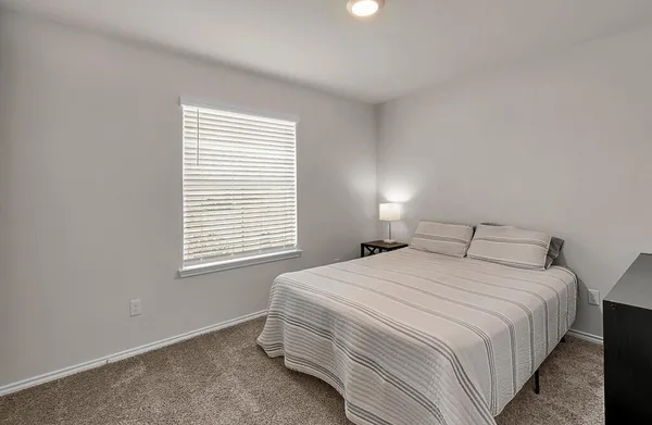 a bedroom with a bed and a window