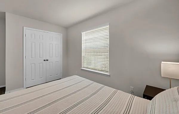 a bedroom with a bed and a window
