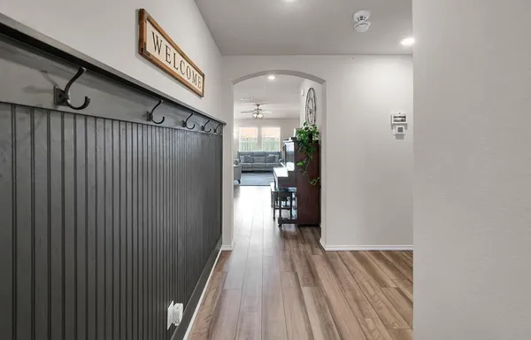 a view of a hallway with wooden floor fireplace and living room