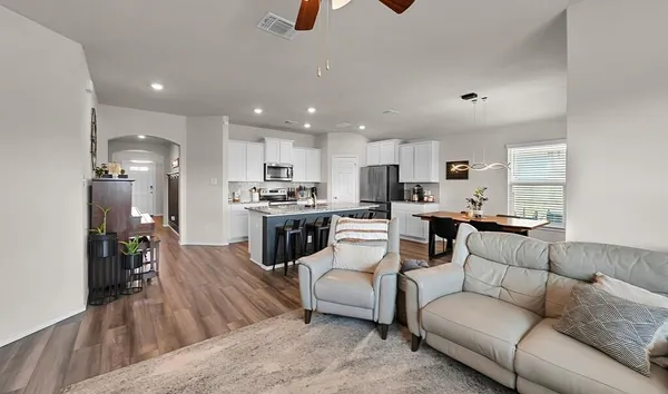 a living room with furniture and kitchen view