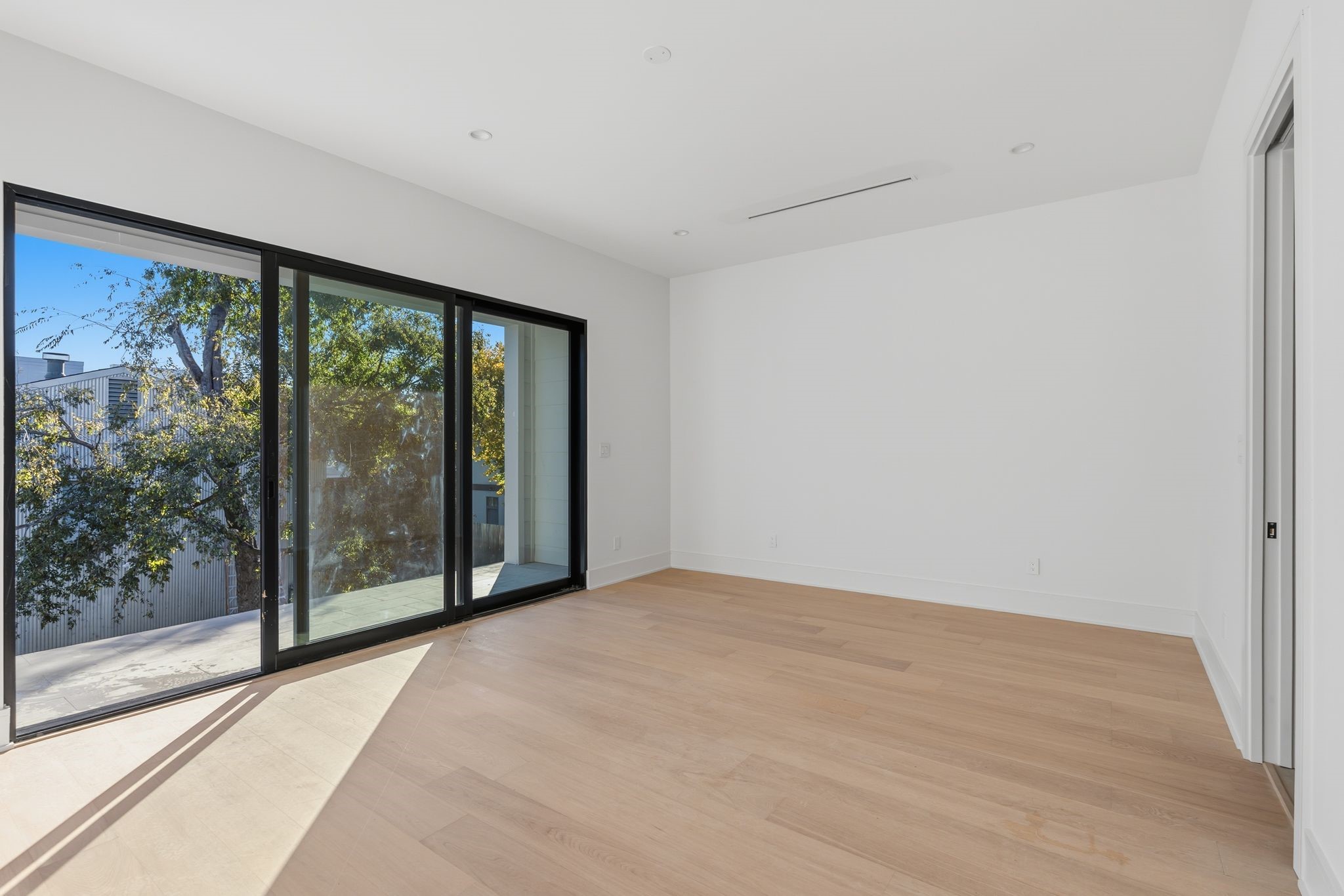 820 Malone Street Houston, TX 77007 - Photo 13 of 31 a view of an empty room with wooden floor and a window