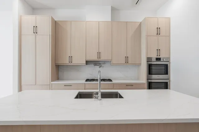 a white kitchen with a sink and cabinets