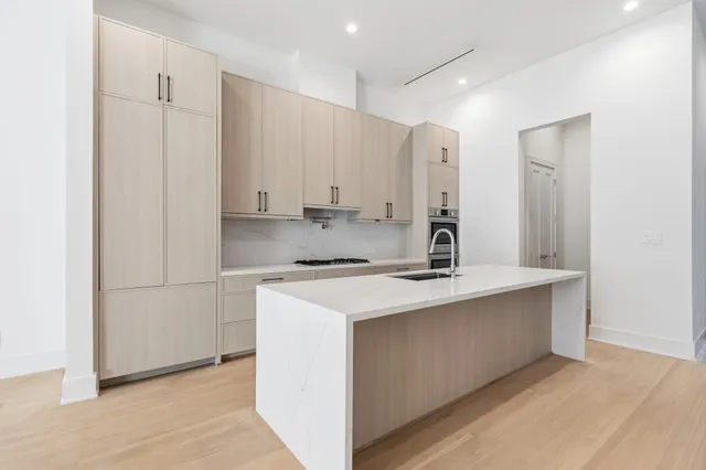 a view of kitchen with stainless steel appliances granite countertop a sink stove and refrigerator