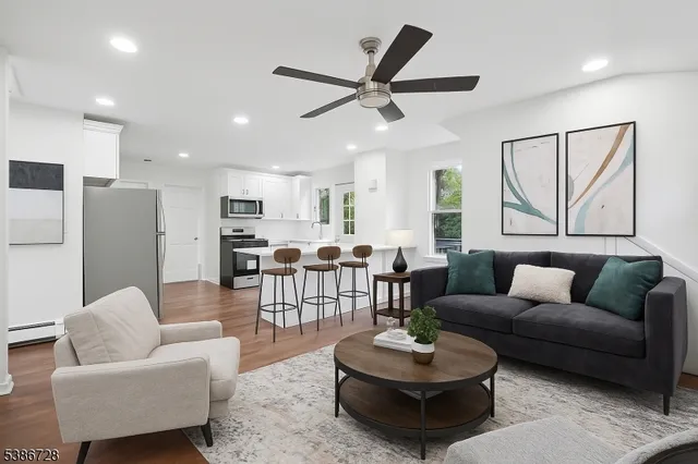 a living room with furniture kitchen view and a window