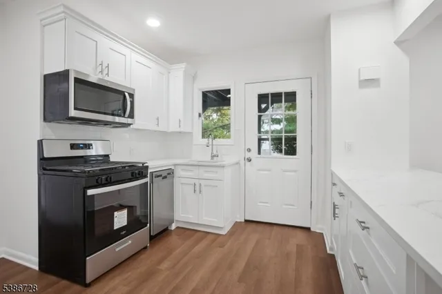 a kitchen with stainless steel appliances a stove microwave and sink