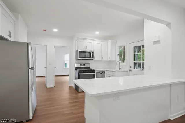 a kitchen with stainless steel appliances a refrigerator and a stove top oven