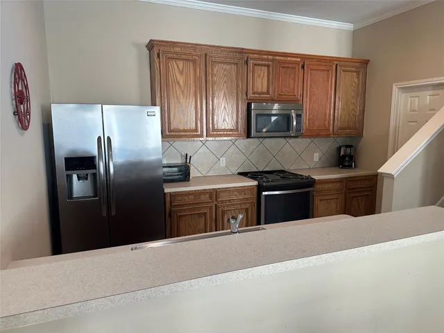 a kitchen with granite countertop a refrigerator and a sink
