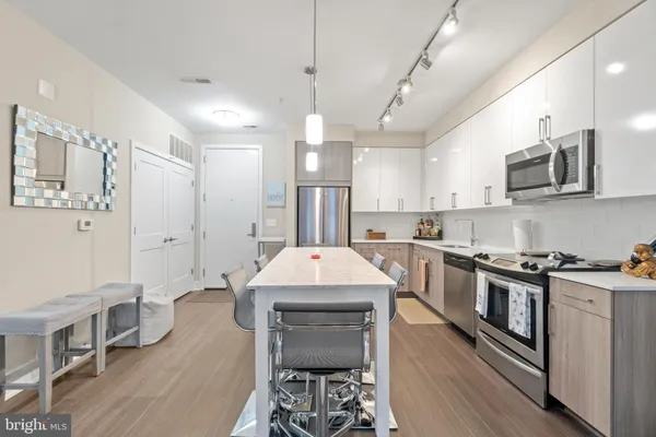 a very nice looking kitchen with granite countertop a stove top oven a sink a counter space and cabinets