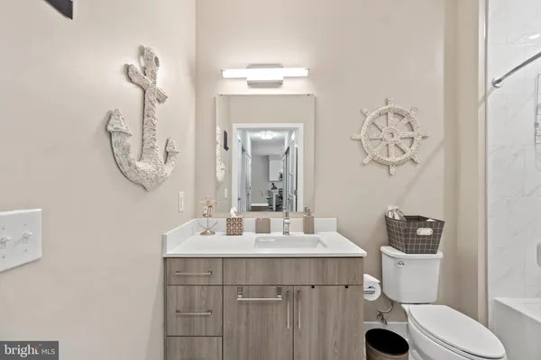 a bathroom with a sink vanity mirror and toilet