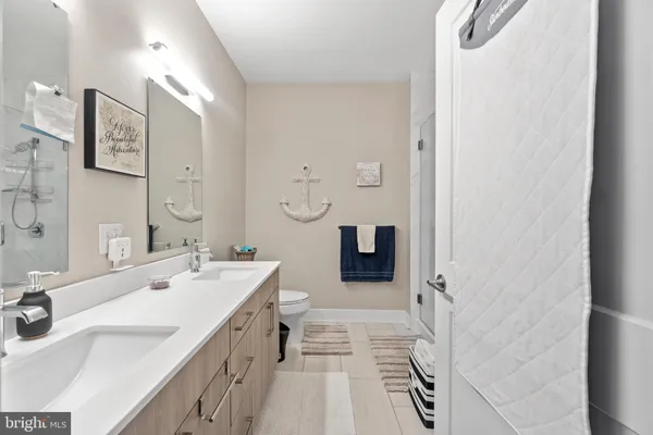 a spacious bathroom with a sink a toilet a mirror and shower