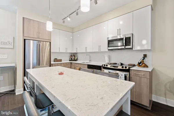 a kitchen with stainless steel appliances a stove refrigerator sink and cabinets