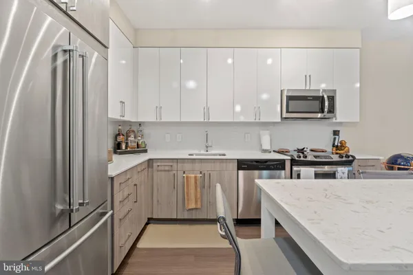 a kitchen with stainless steel appliances granite countertop a refrigerator a stove top oven a sink and dishwasher