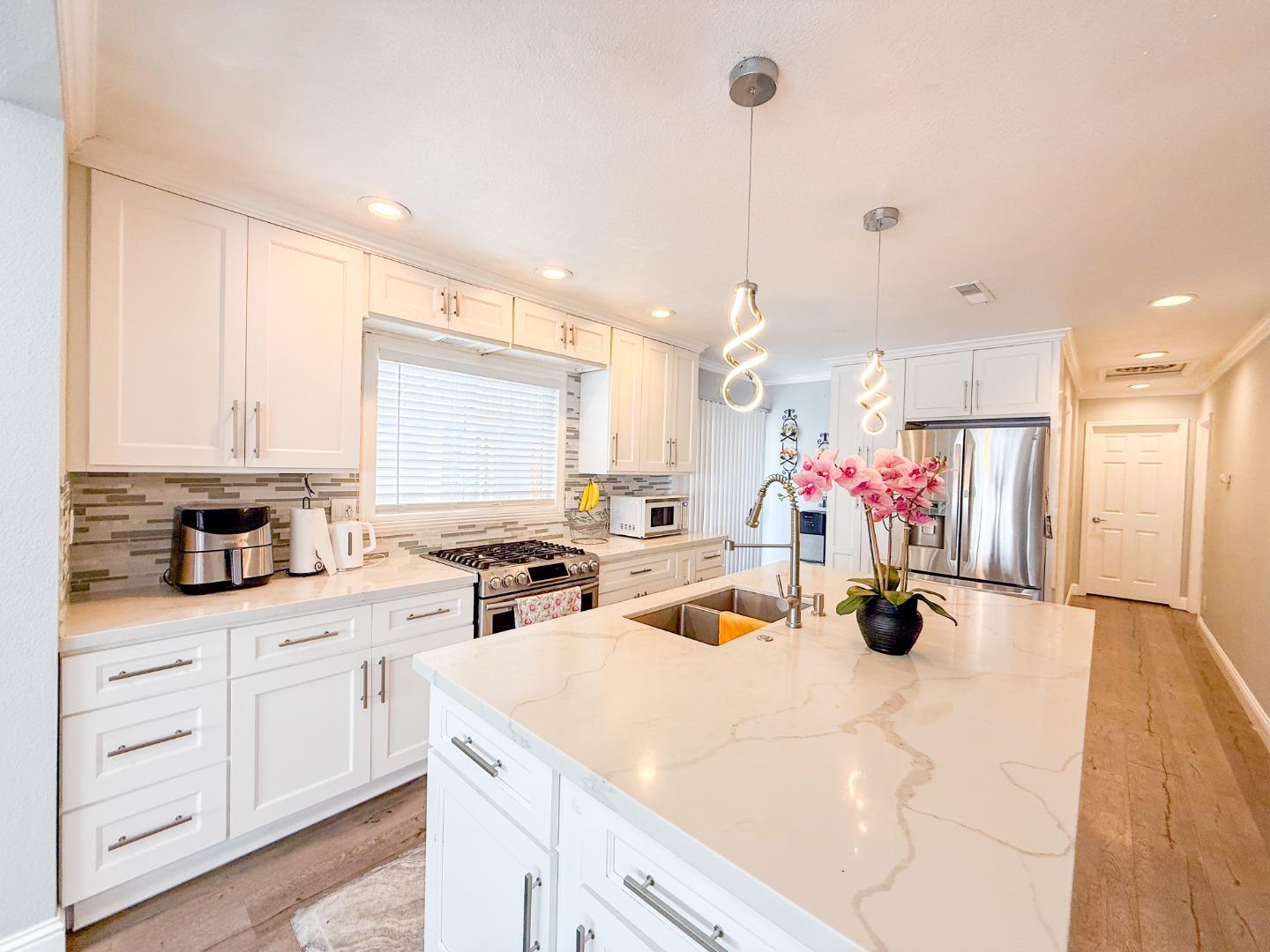 6130 Monterey Road, Unit 22 San Jose, CA 95138 - Photo 5 of 21 a view of a kitchen with kitchen island a sink stainless steel appliances and cabinets