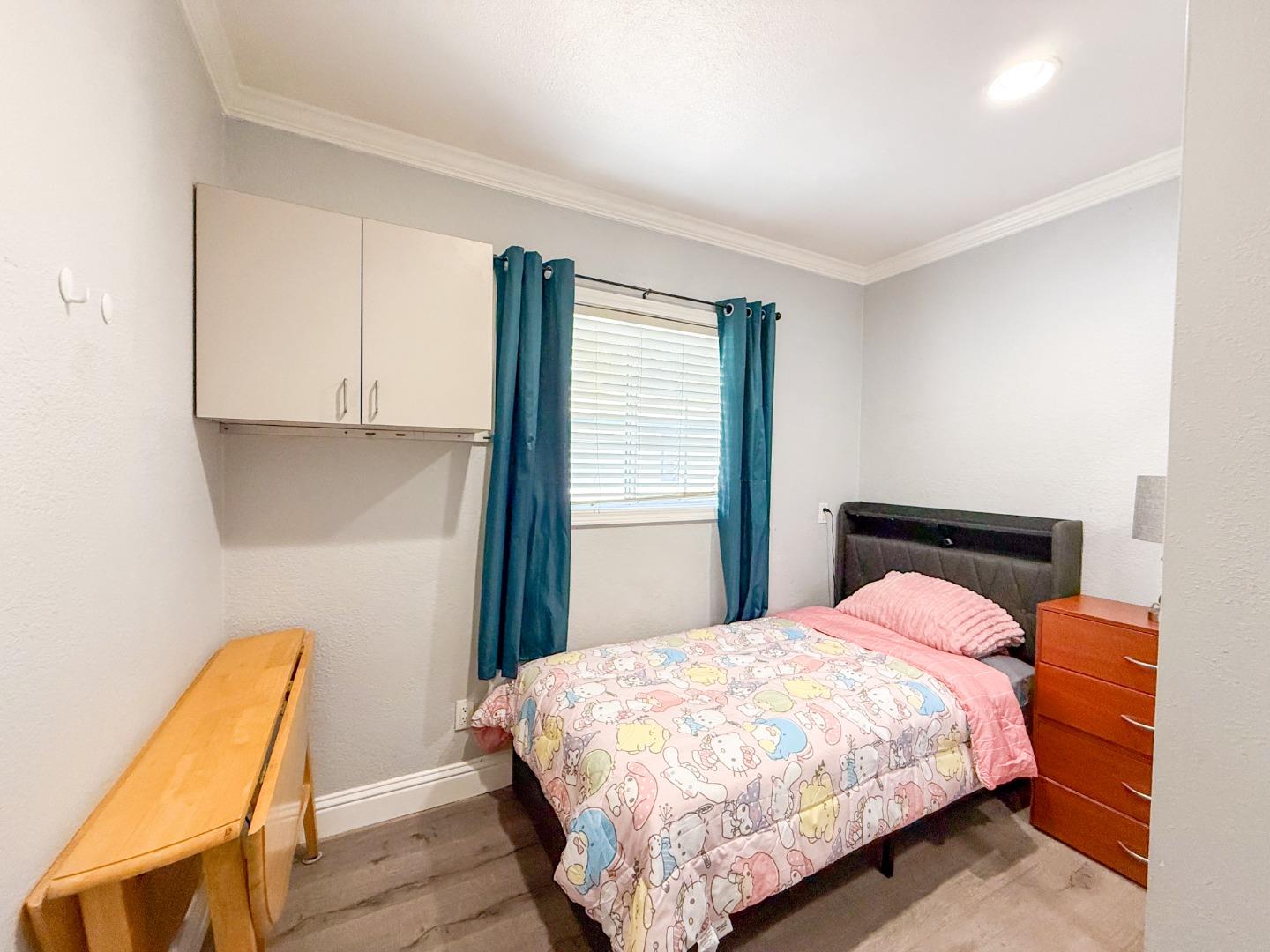 6130 Monterey Road, Unit 22 San Jose, CA 95138 - Photo 10 of 21 a bedroom with a bed and wooden floor