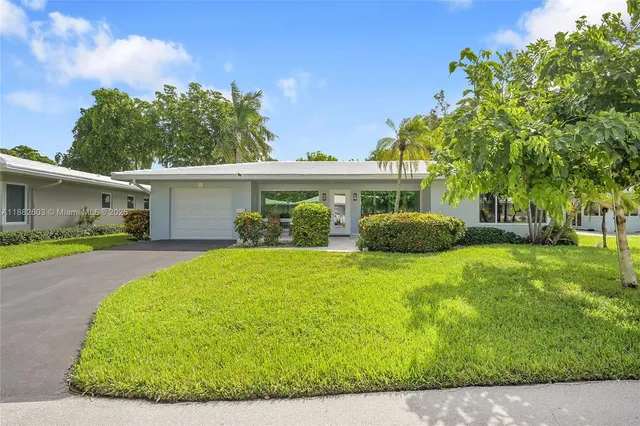 a balcony with couple of chairs and a potted plant