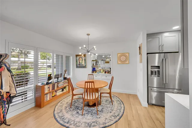 a dining room with furniture a chandelier and wooden floor