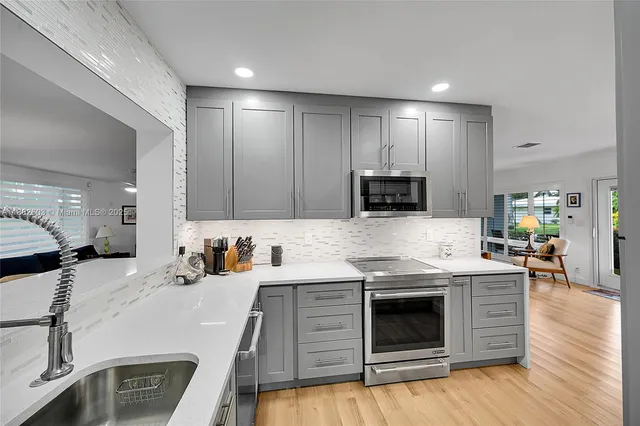 a kitchen with a sink stove and wooden floor
