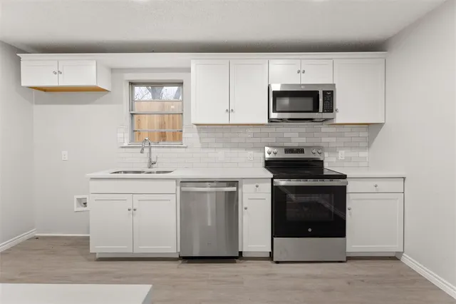 a kitchen with stainless steel appliances granite countertop a sink and a microwave