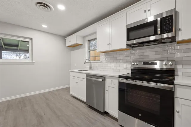 a kitchen with stainless steel appliances granite countertop a stove and a microwave