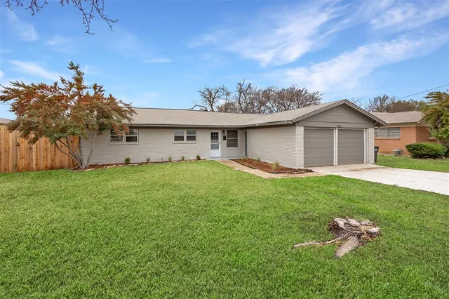 a front view of a house with a garden and yard