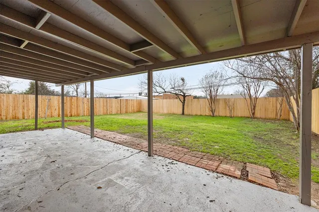 a view of a backyard with wooden fence