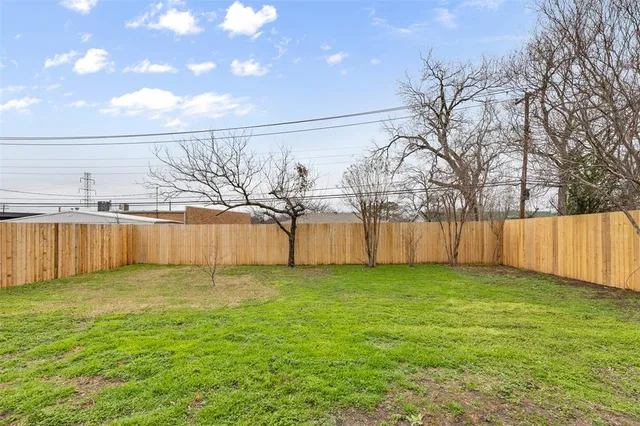 a view of a yard with wooden fence