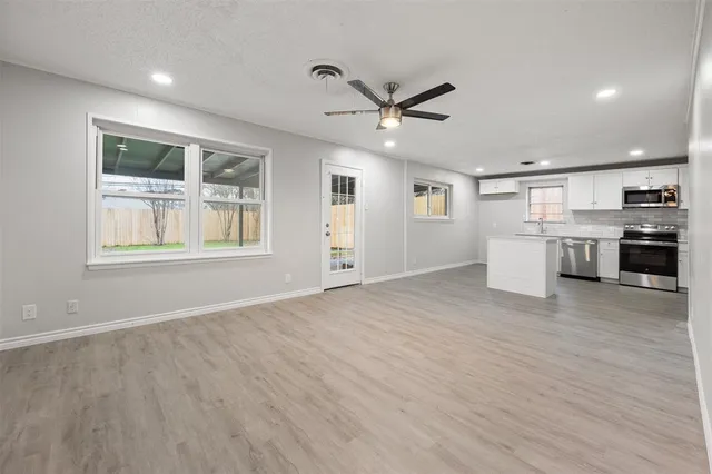 a view of a kitchen with a sink dishwasher a stove and a microwave oven with cabinets