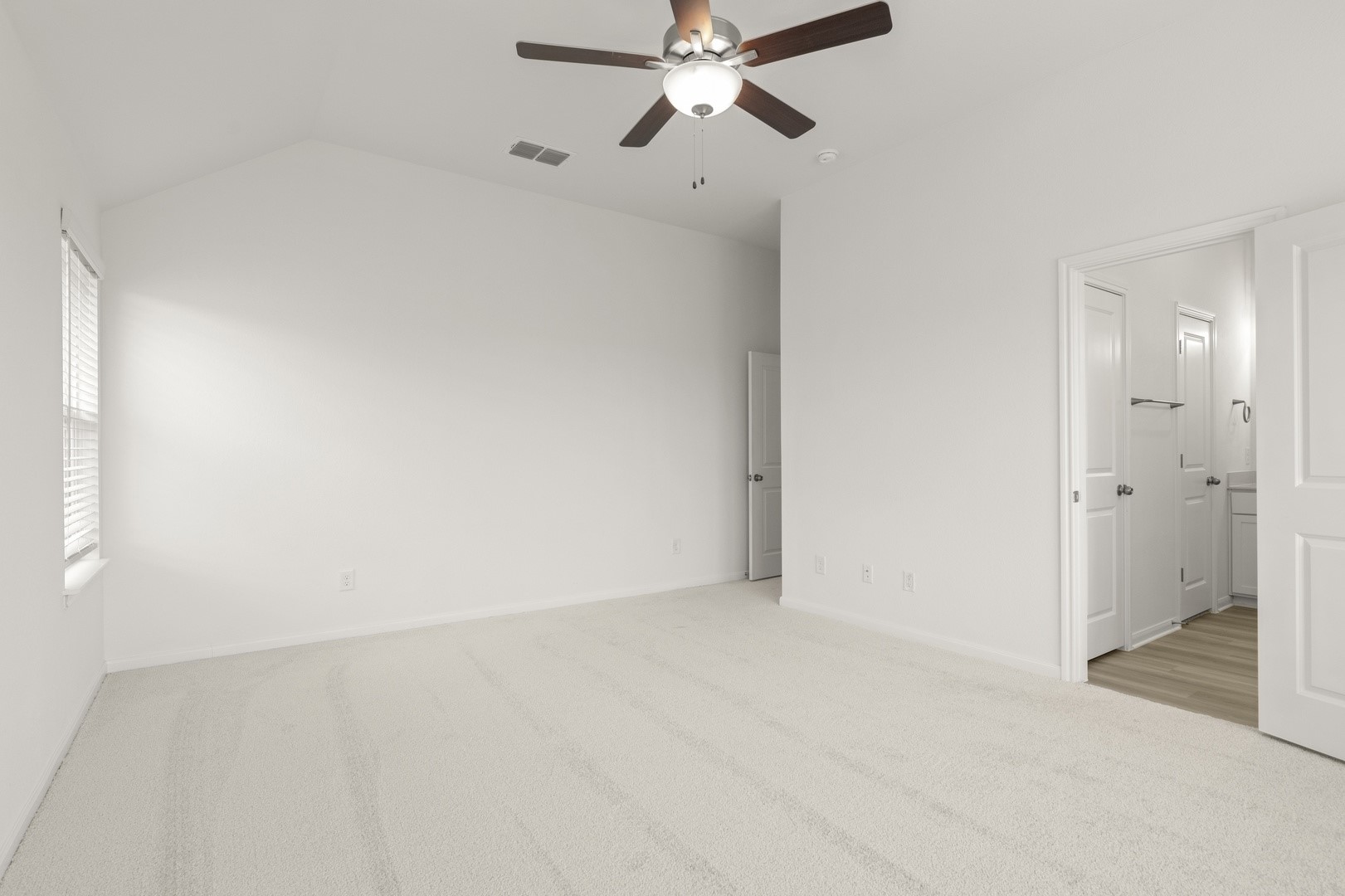 3729 Pin Oak Hills Seguin, TX 78155 - Photo 15 of 22 Unfurnished bedroom with light colored carpet, ceiling fan, vaulted ceiling, and connected bathroom