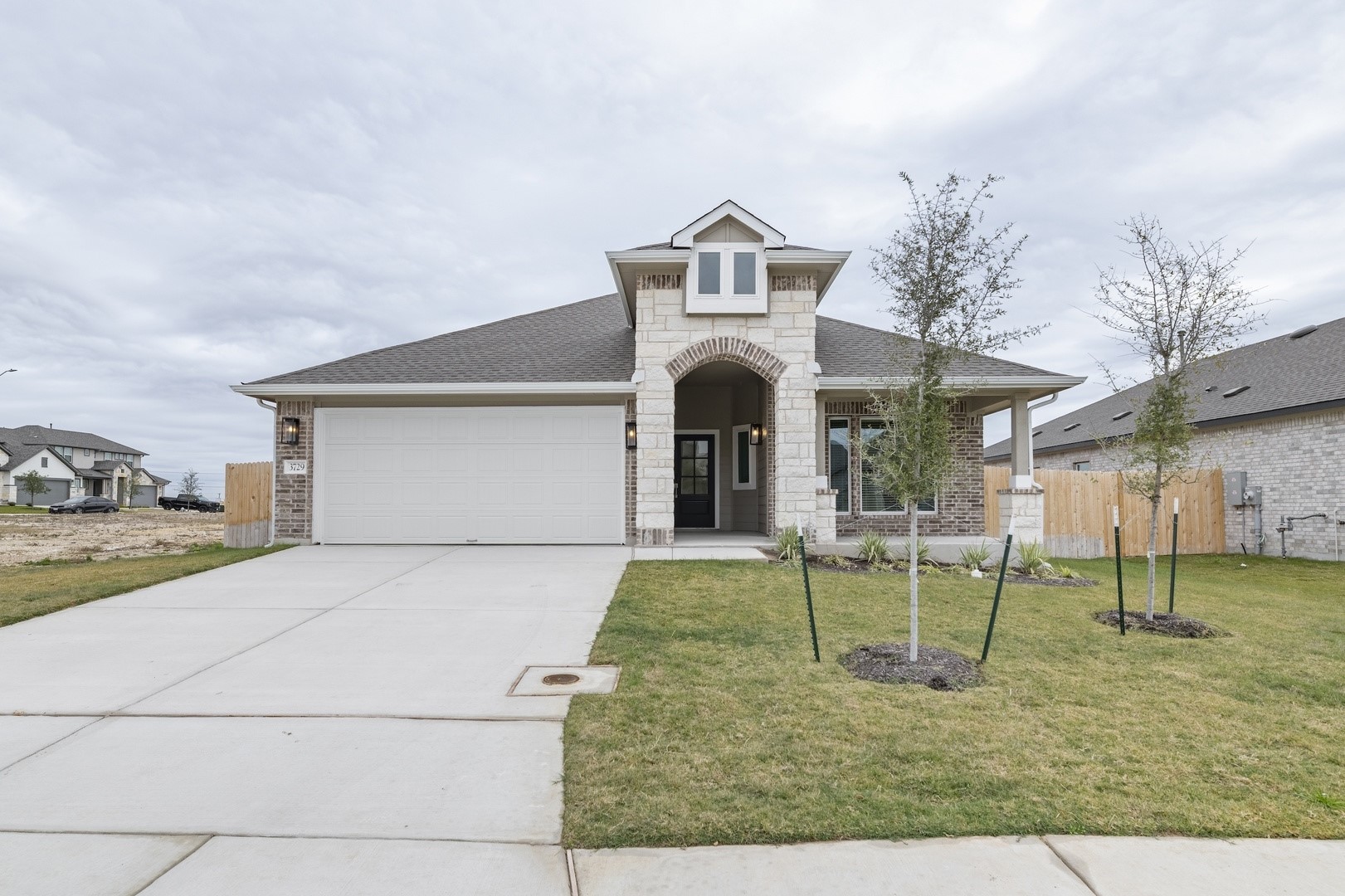 3729 Pin Oak Hills Seguin, TX 78155 - Photo 2 of 22 View of front of home featuring stone siding, concrete driveway, a shingled roof, a garage, and a porch