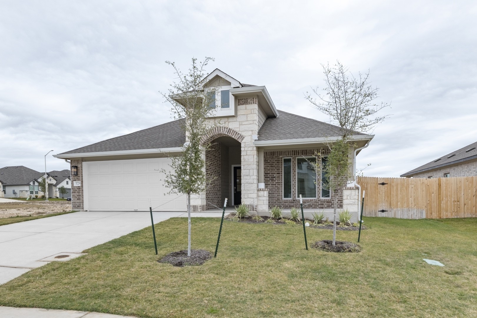 3729 Pin Oak Hills Seguin, TX 78155 - Photo 3 of 22 View of front of property featuring brick siding, concrete driveway, roof with shingles, a garage, and stone siding