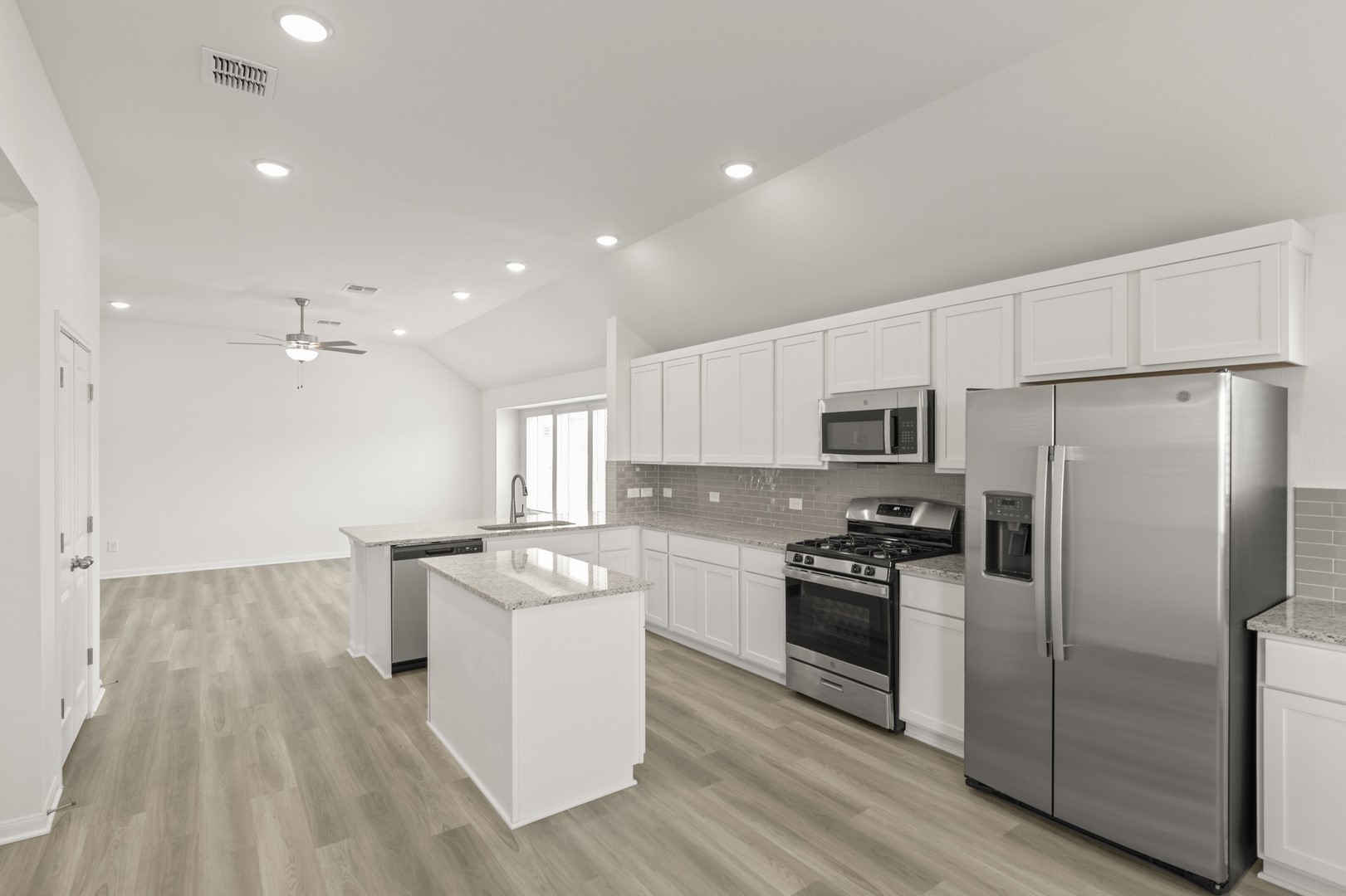 3729 Pin Oak Hills Seguin, TX 78155 - Photo 4 of 22 Kitchen with appliances with stainless steel finishes, white cabinets, decorative backsplash, a peninsula, and vaulted ceiling