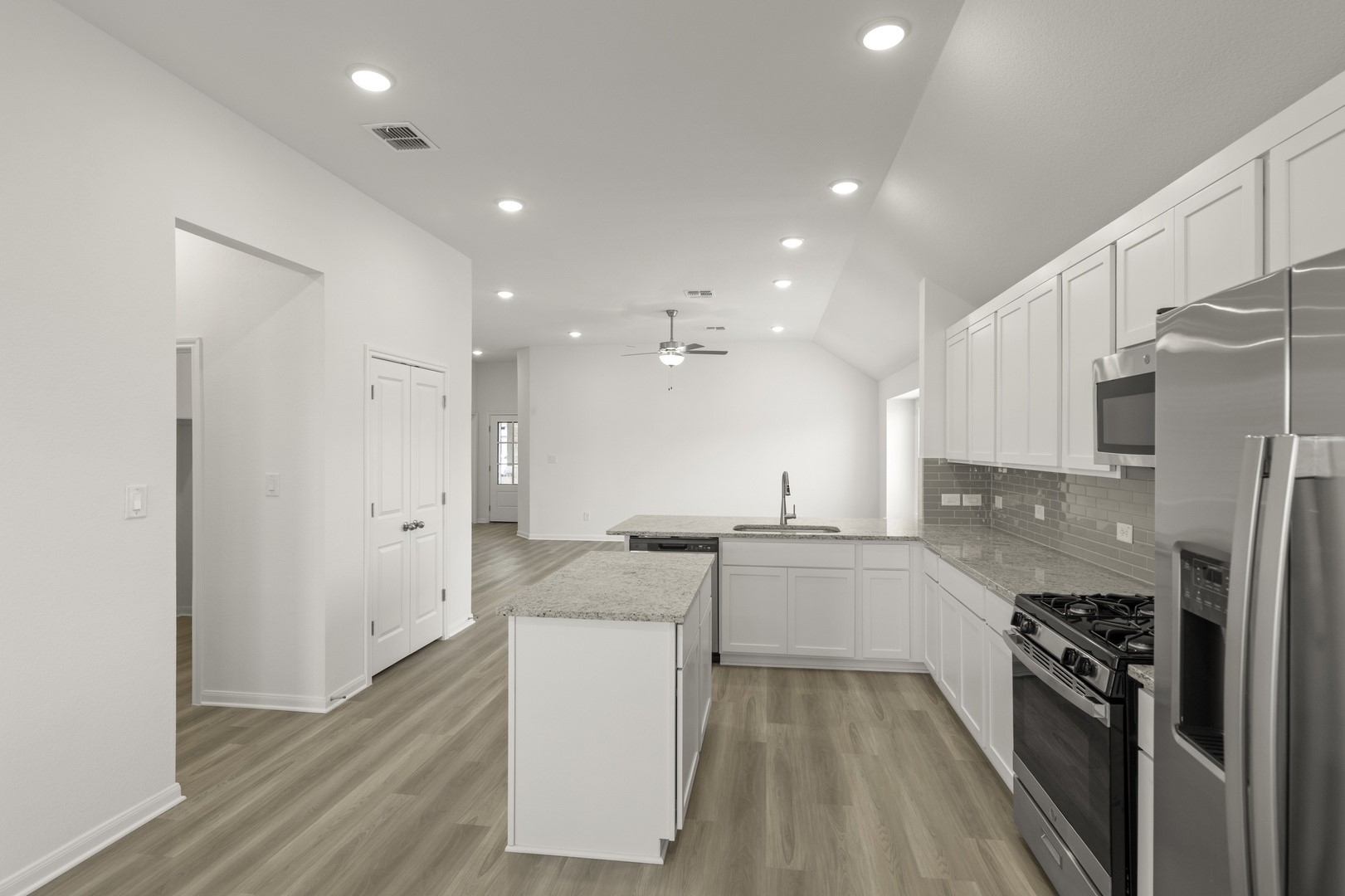 3729 Pin Oak Hills Seguin, TX 78155 - Photo 5 of 22 Kitchen with appliances with stainless steel finishes, white cabinets, a kitchen island, vaulted ceiling, and light wood finished floors